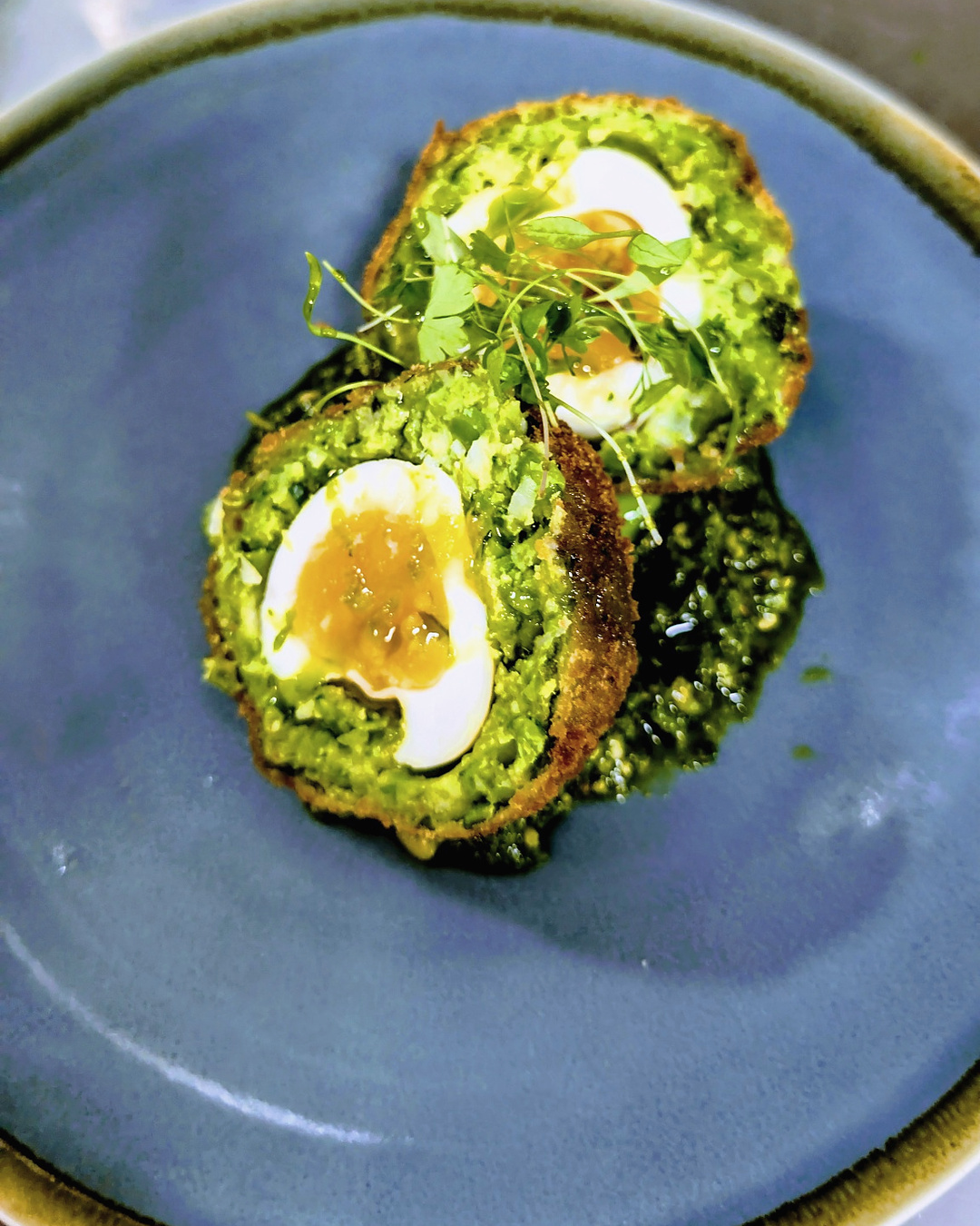 Craig’s smoked haddock Scotch egg, halved over a green dressing